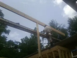 Carpenter setting a ridge beam over a new addition frame — Ice Dam Removal by Roofing Brothers in Shelocta