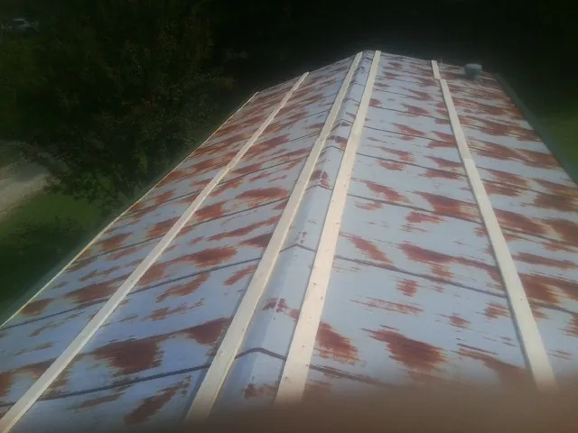 Rusted metal roof panels with new wood purlins before replacement — Storm Damage Roof Repair in Shelocta by Roofing Brothers