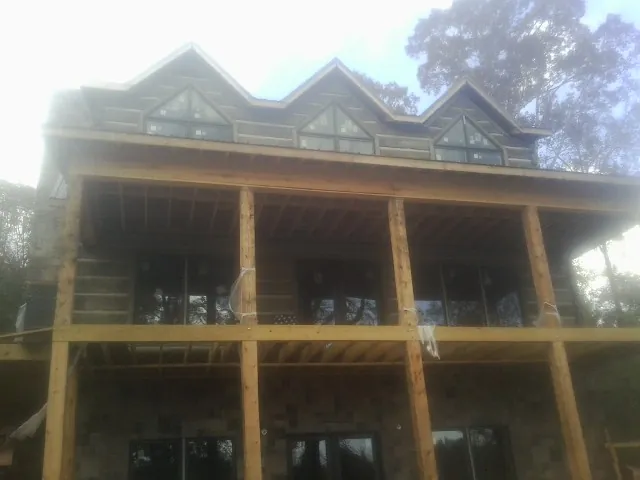 Dormers and porch framing on a large log home under construction — Roof Coating work by our crew in Shelocta