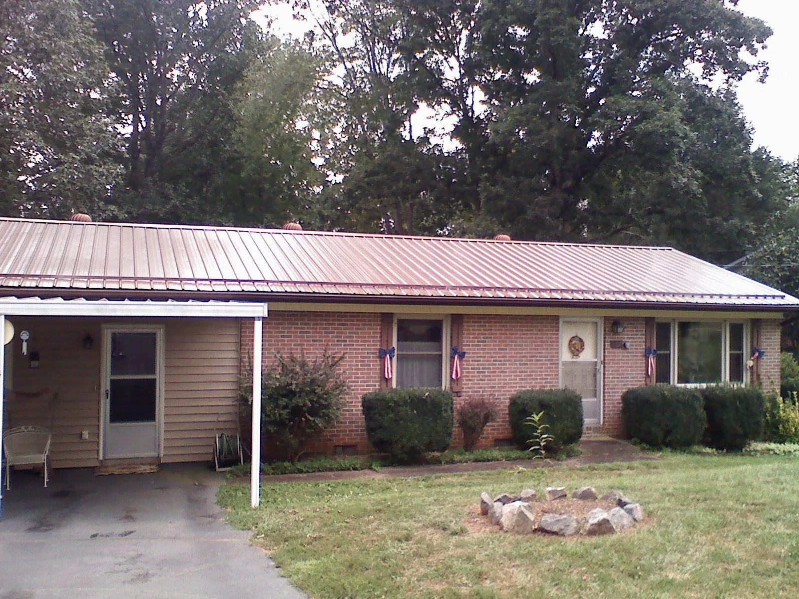 Bronze metal roof and carport on a brick ranch home — Roof Repair work by our crew in Shelocta